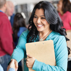 Female volunteer greeting woman at facility.
